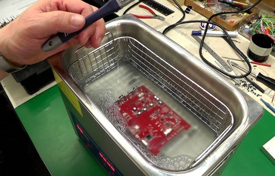 PCB undergoing post-reflow cleaning to remove flux residue