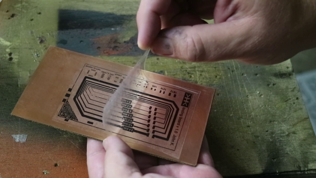 Transferred PCB design on copper-clad board for etching.