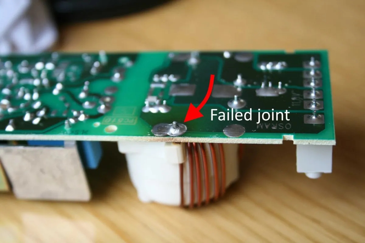 Damaged pacemaker PCB showing solder joint cracks and corrosion