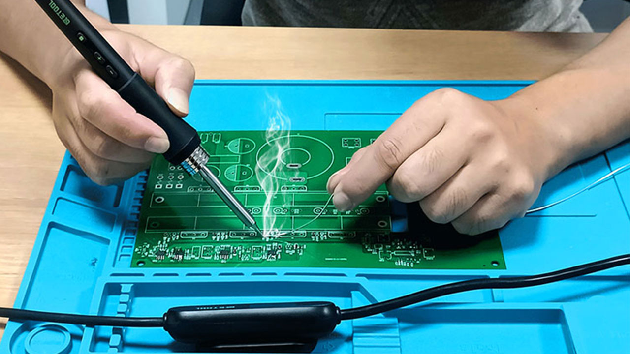 Soldering iron for PCB repair in action"