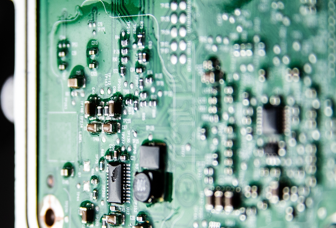 Close-up of a PCB with conformal coating for space probe protection.
