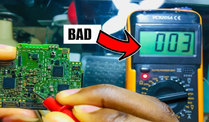 Technician testing a CT scanner PCB with a multimeter for voltage issues