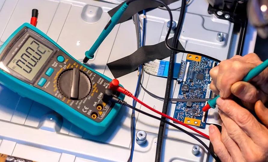 Technician diagnosing electromechanical device with a multimeter.