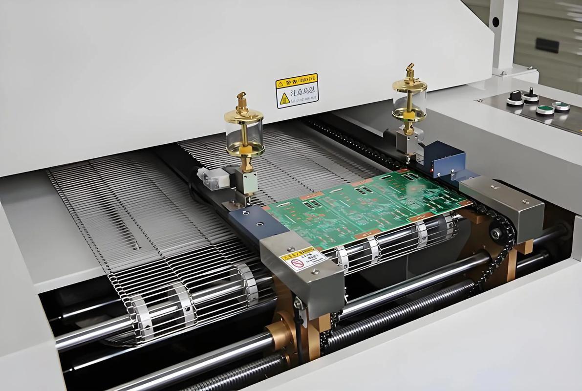 Wave soldering machine in operation for through-hole component PCB assembly.