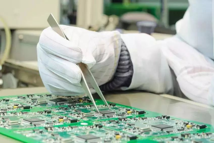 Workspace setup for ECU PCB repair with soldering tools and anti-static protection