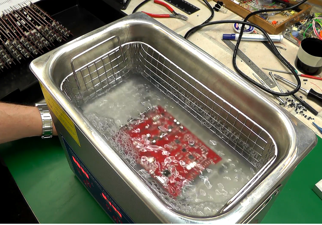 PCB undergoing ultrasonic cleaning to remove no-clean flux residue