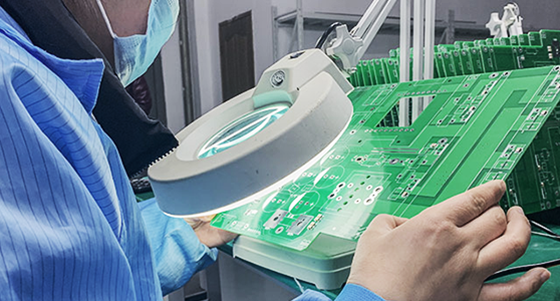 Technician conducting visual inspection on a PCB for quality control