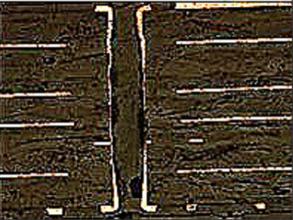Polished PCB cross-section under a microscope revealing internal layers.