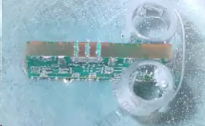 Technician preparing a PCB sample for microsectioning with precision tools.