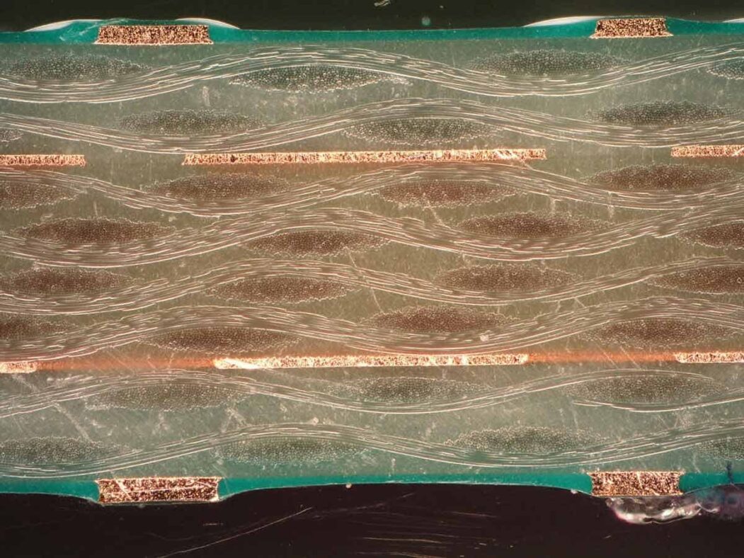 Close-up of FR-4 PCB showing copper traces and laminate structure