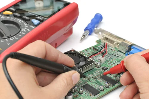 Technician testing FR-4 PCB with multimeter for short or open circuits
