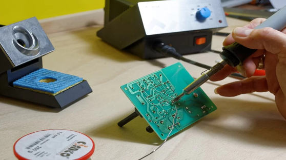 PCB repair tools including soldering iron and multimeter