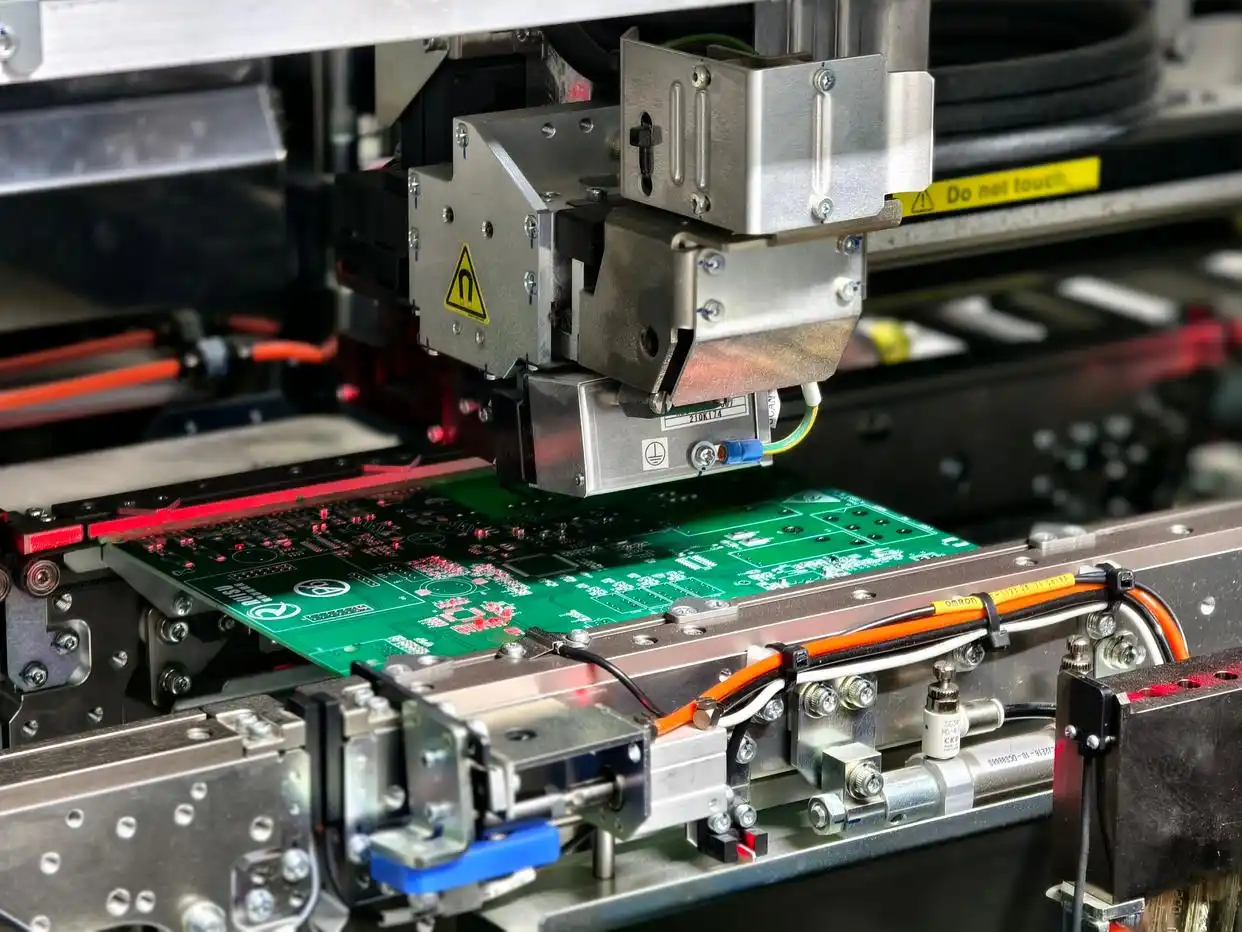 SMT assembly machine placing components on a PCB panel