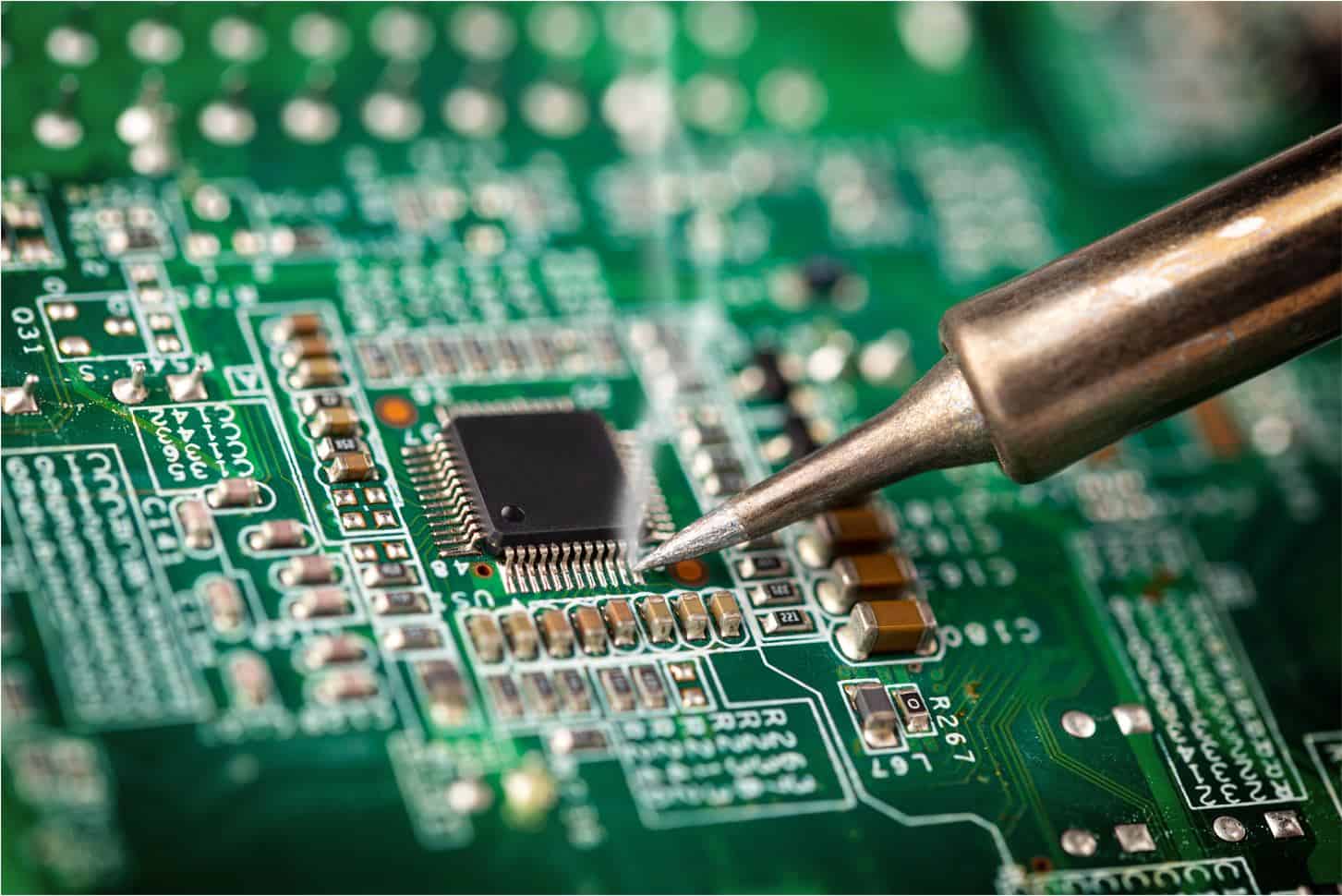 Close-up of PCB prototyping assembly process with soldered components