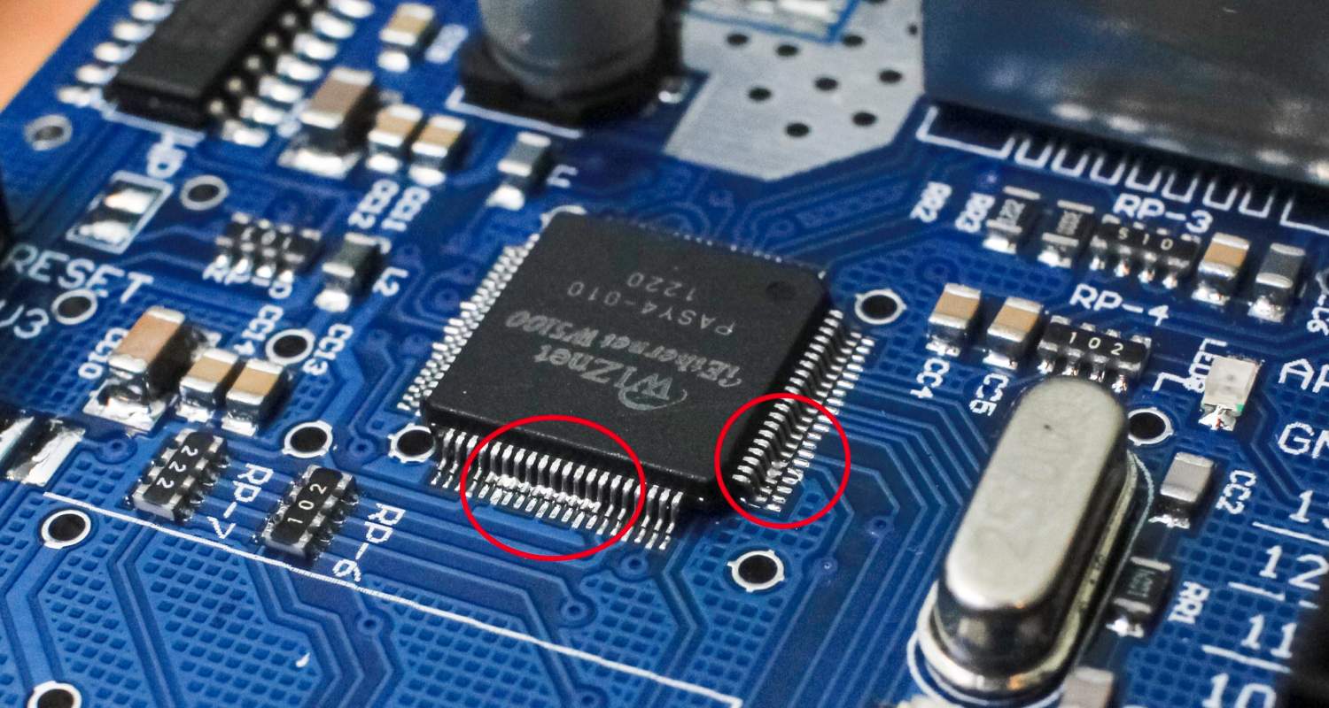Magnified view of SMT defects in microelectronics showing a solder bridge