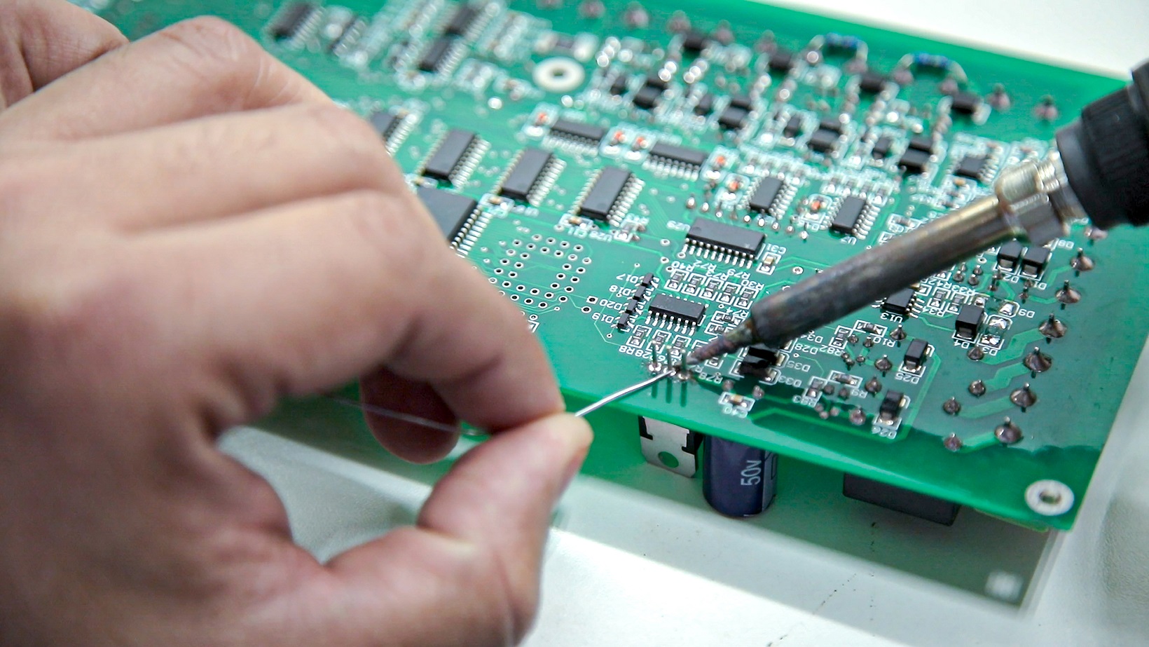 Beginner assembling a circuit board with soldering iron and components