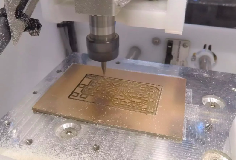 Milling machine removing solder mask from PCB with precision cutter.