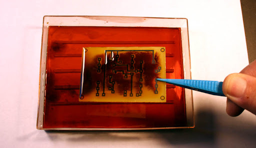 Essential tools and materials for homemade PCB etching with ferric chloride.