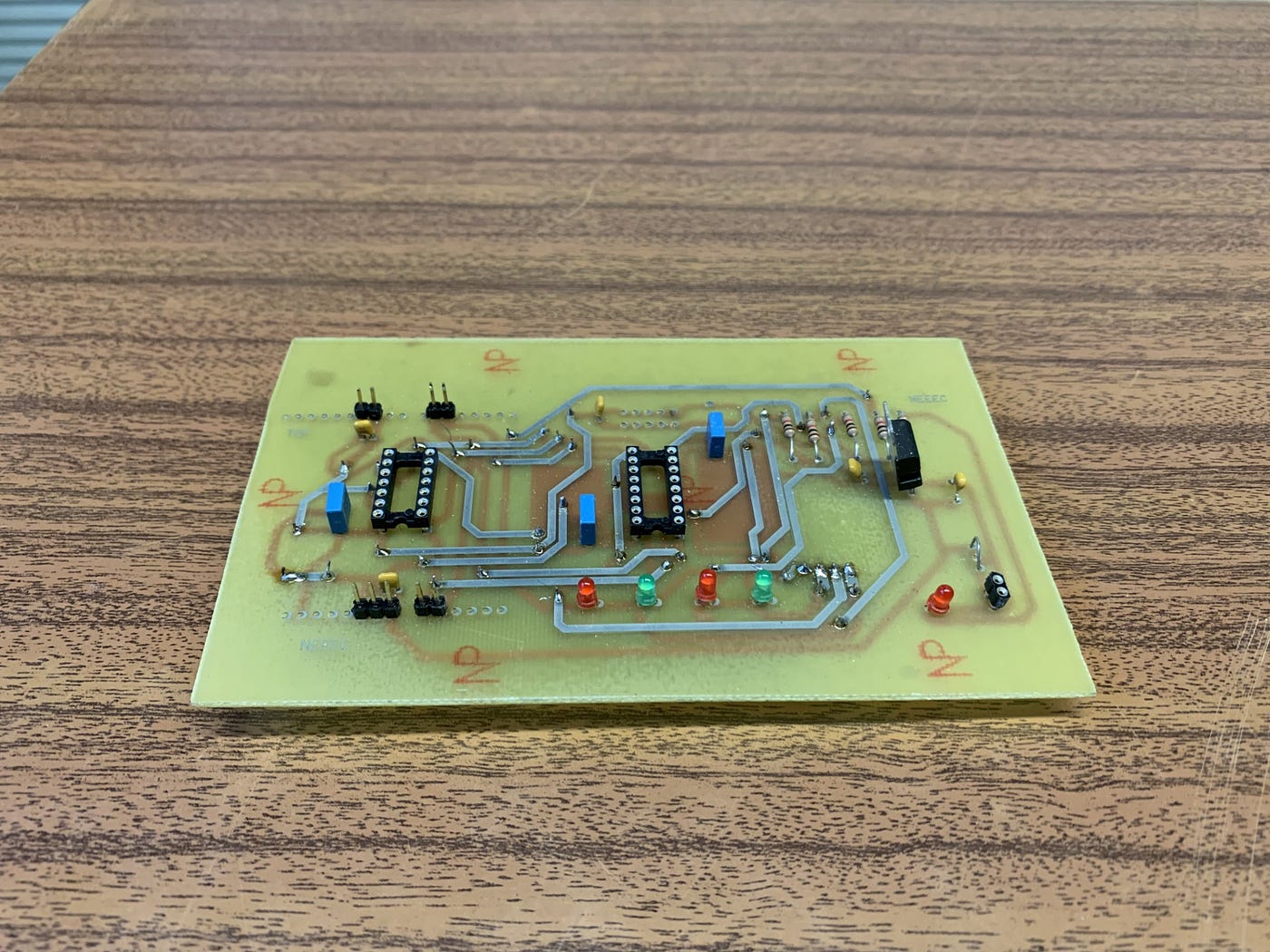 Finished homemade PCB with soldered components after ferric chloride etching.