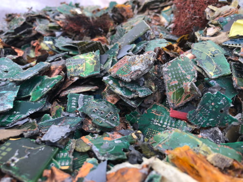 Landfill site overflowing with electronic waste and discarded PCBs.