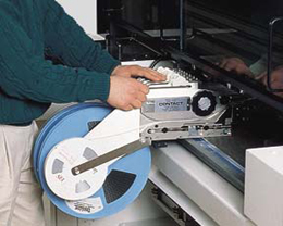 Technician setting up SMT tape feeder for component placement