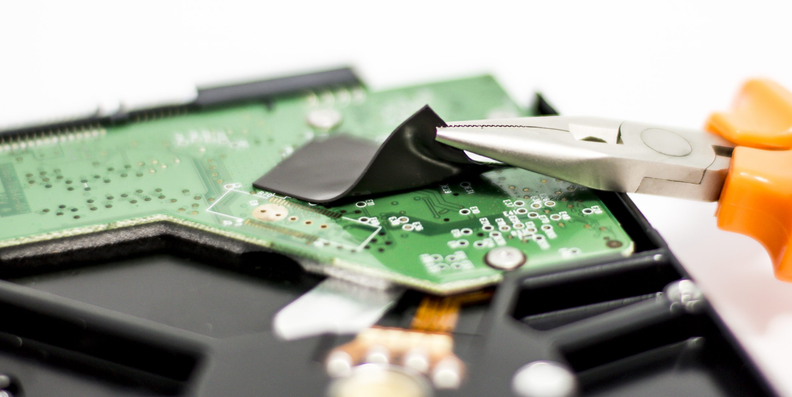 Applying thermal tape for heat sink attachment on a PCB.