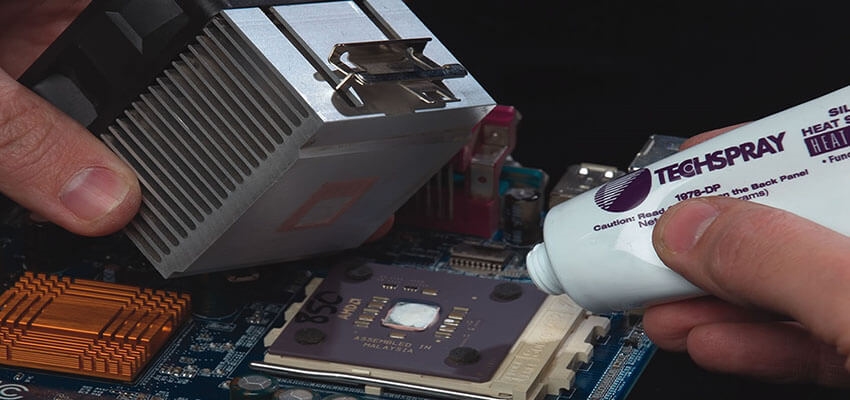 Applying thermal adhesive for permanent heat sink mounting on a PCB.