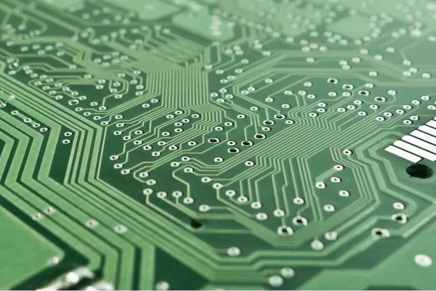 Close-up of a PCB with green solder mask layer protecting copper traces.