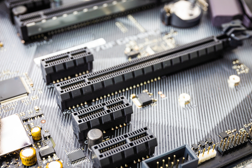 PCB with hard gold plated edge connectors being inserted into a slot.