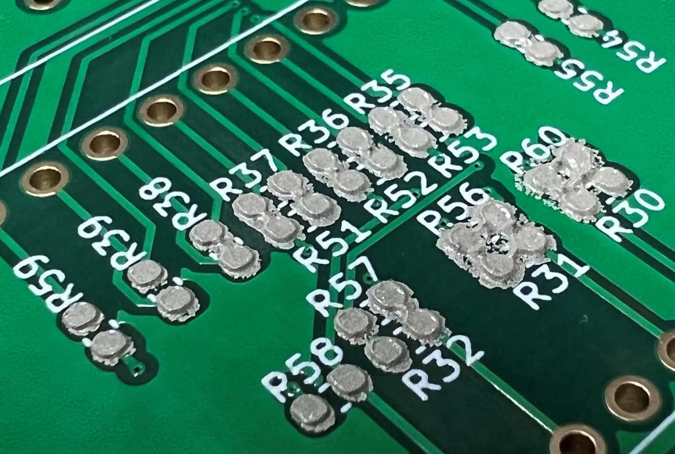 Close-up of solder paste applied to PCB pads using a stencil printer.