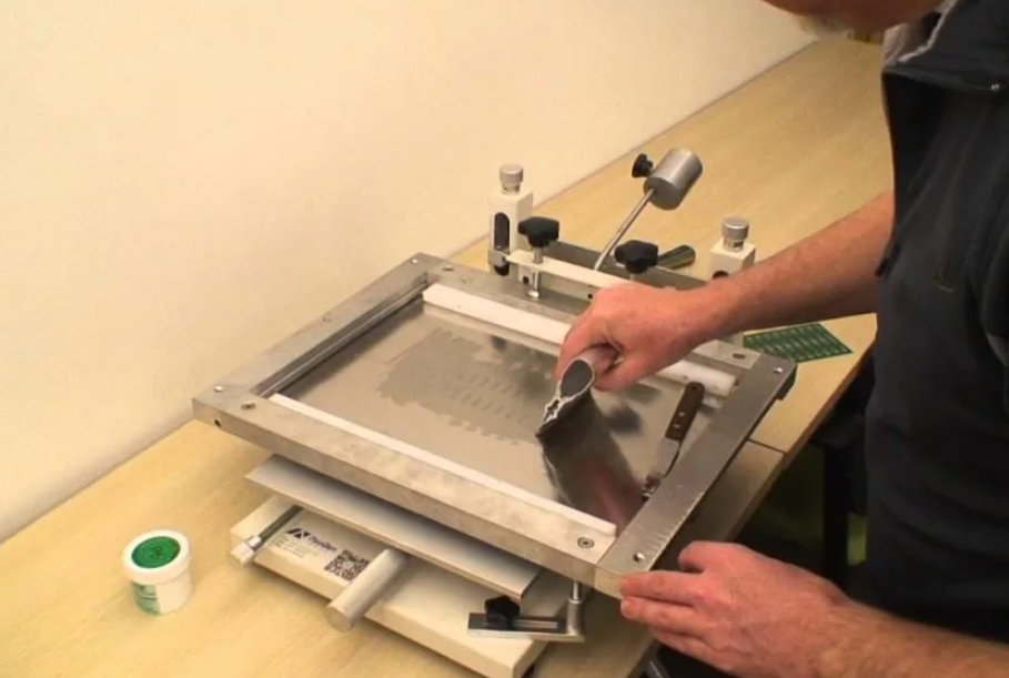 Using a manual stencil printer to apply solder paste on a PCB.
