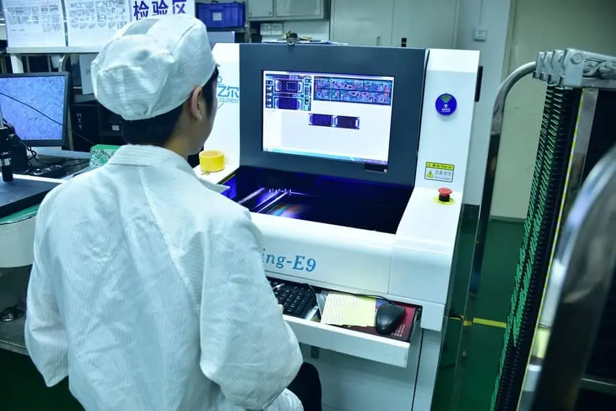 Technician configuring an AOI system for PCB inspection.