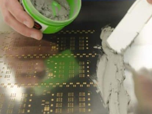 Stencil printer applying lead-free solder paste on PCB for SMT assembly.