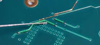 Repairing a broken trace on a mobile phone PCB with a jumper wire.