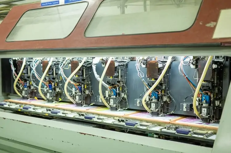 CNC machine drilling holes in a PCB for precision manufacturing.