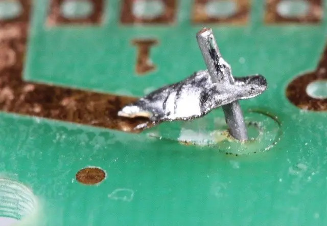 Close-up view of a lifted solder pad on a printed circuit board.