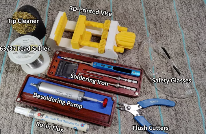 Essential tools for solder pad repair including soldering iron, flux, and desoldering braid.