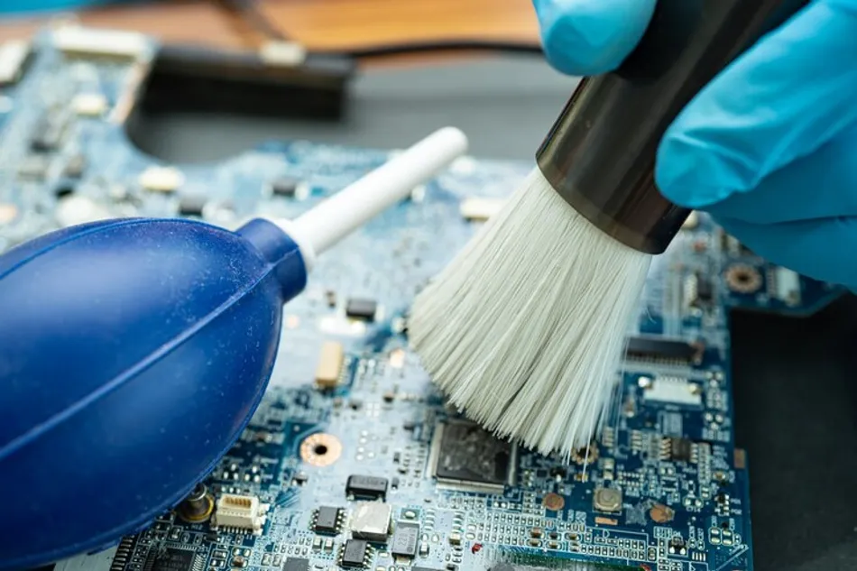 Cleaning printed circuit board with spray and brush in a safe environment.