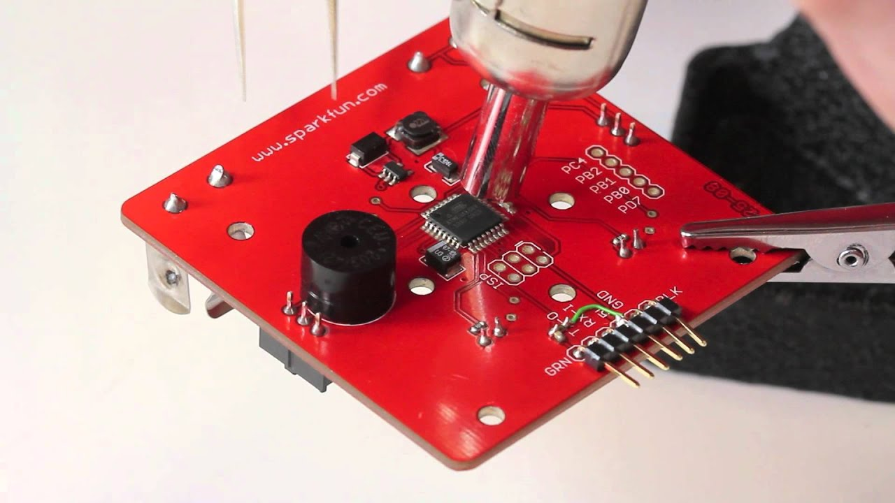 Using a hot air rework station for SMT component removal on a PCB.