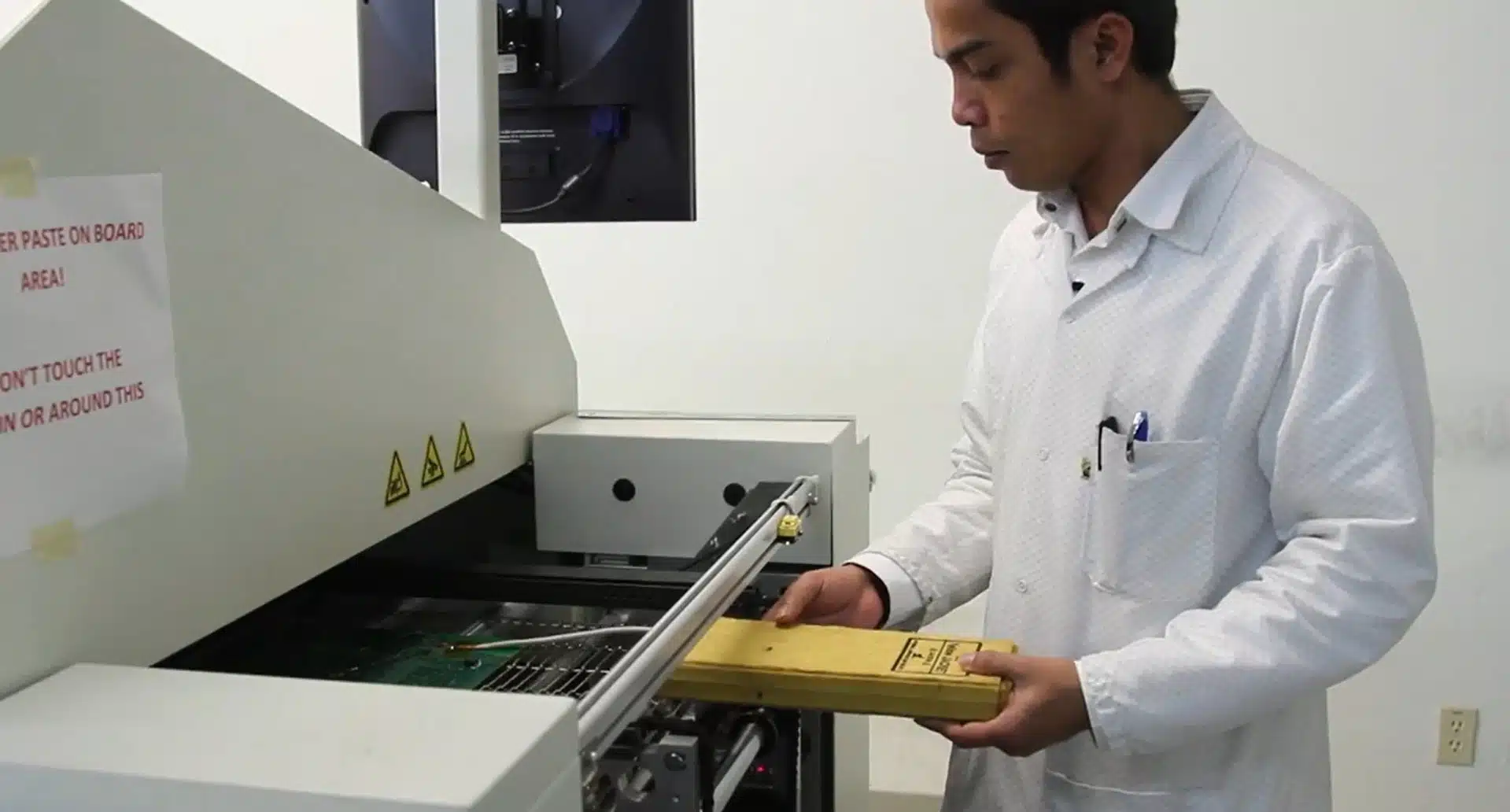 Technician maintaining a solder reflow oven