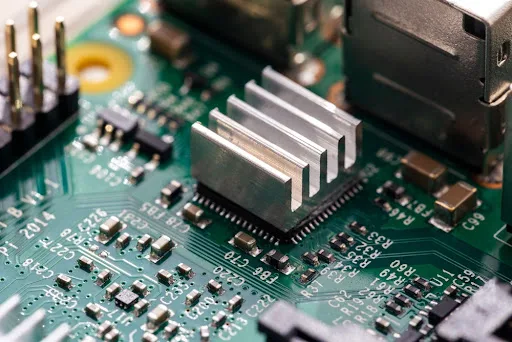 Extruded aluminum heat sink attached to QFP package on multilayer PCB