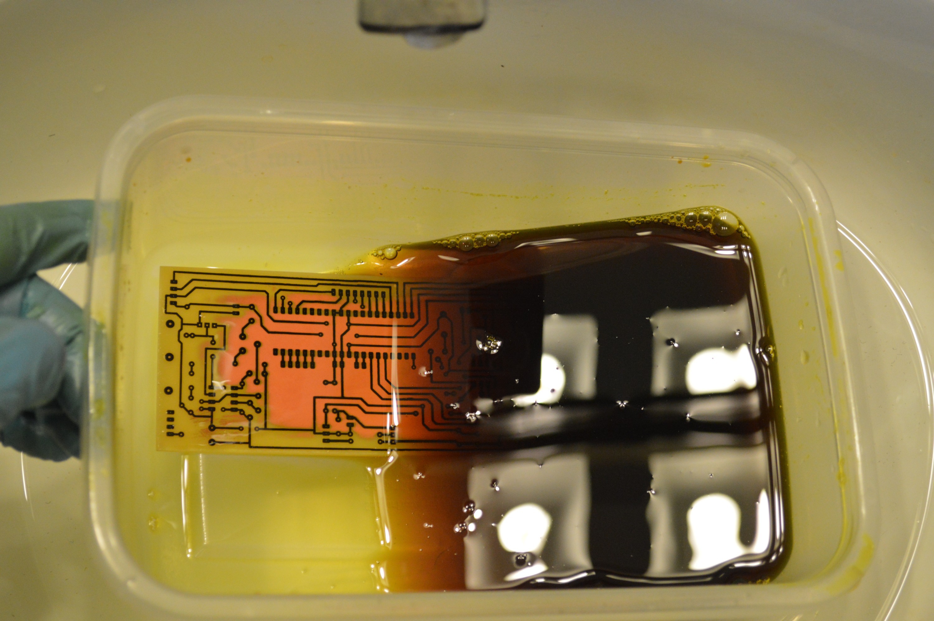 PCB in bubbling ferric chloride etchant bath for uniform trace etching