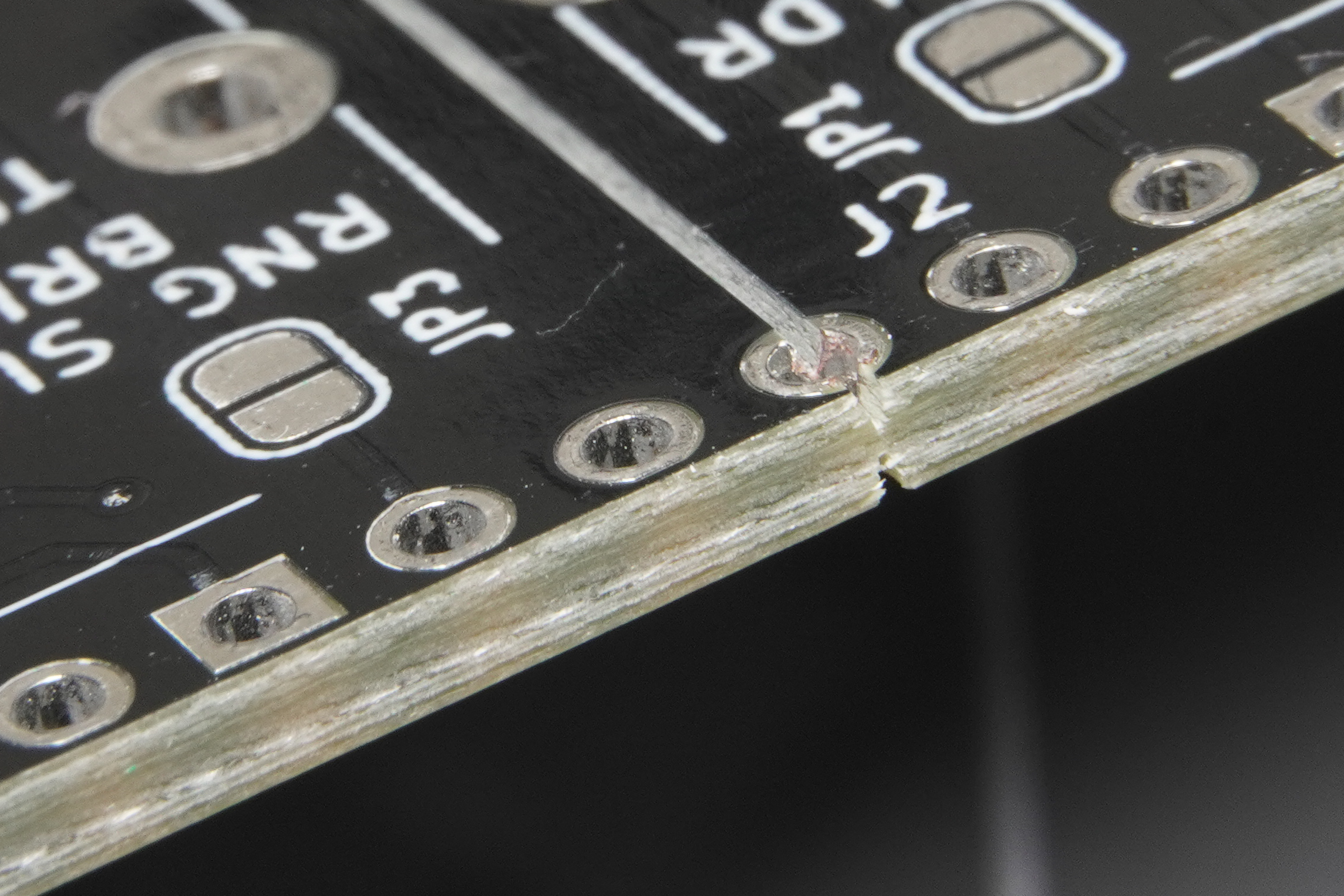 Close-up of V-groove scoring on a PCB panel illustrating depaneling break line