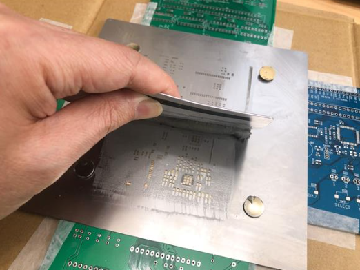 Applying solder paste through mini-stencil aligned on exposed PCB pads