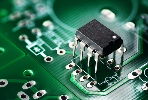 Close-up of leads inserted into PCB vias for THT assembly