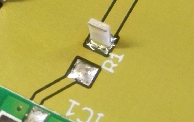 SMT chip capacitor showing tombstoning due to uneven solder paste volume