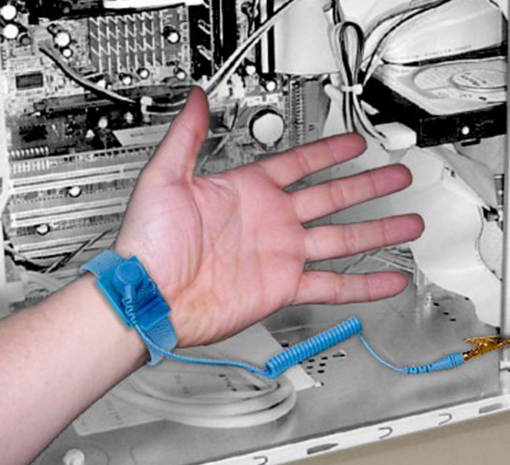 Operator wearing grounding wrist strap while handling a BGA component on a dissipative mat