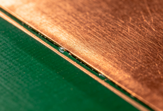Microscopic view of solder mask edges and copper clearance on a PCB