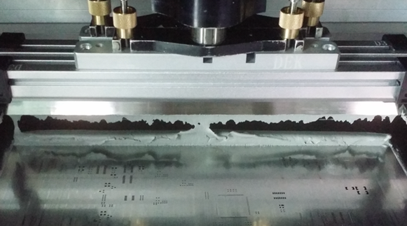 Close-up of stencil printing solder paste onto PCB pads with glossy solder mask