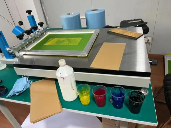 Hobbyist applying silkscreen ink to an etched PCB panel